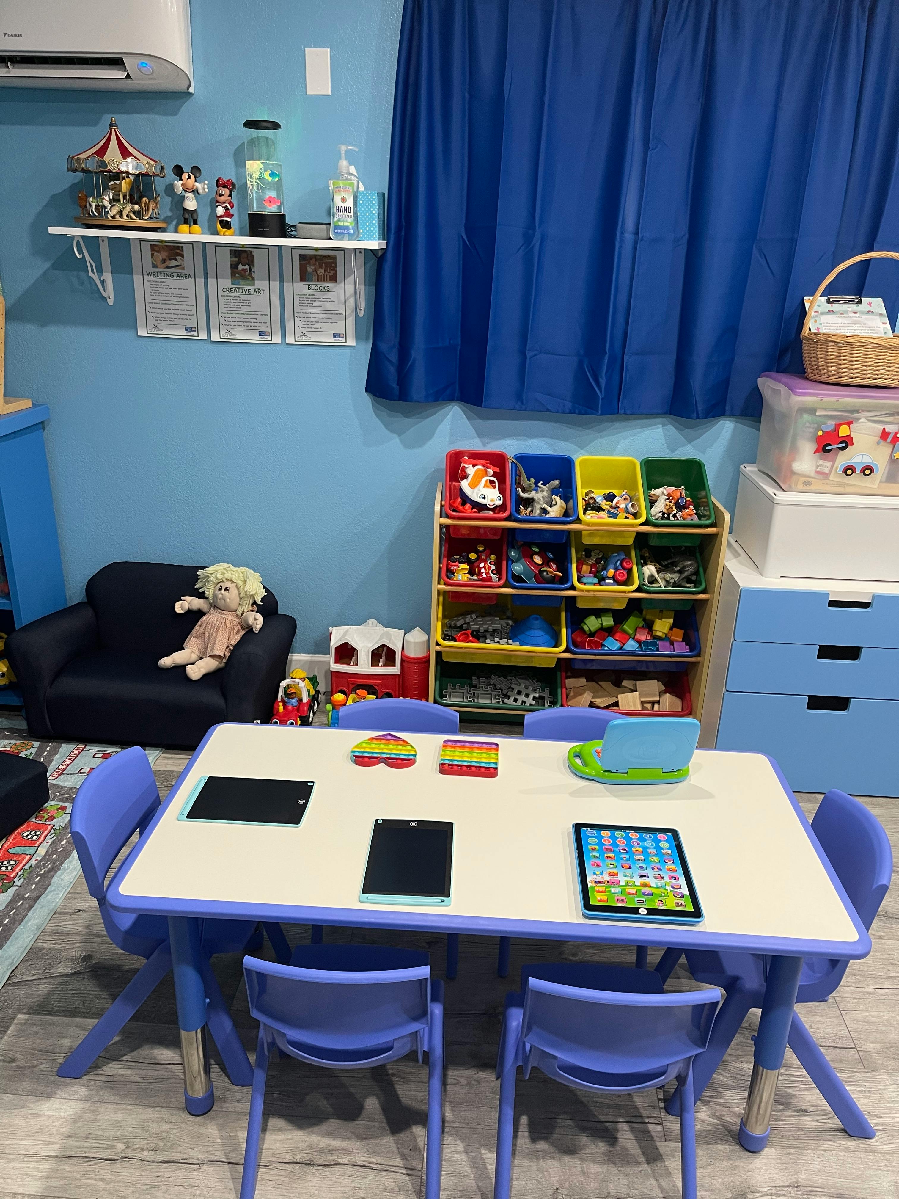 Children's play area with a table and chairs, toy storage, and a small armchair
