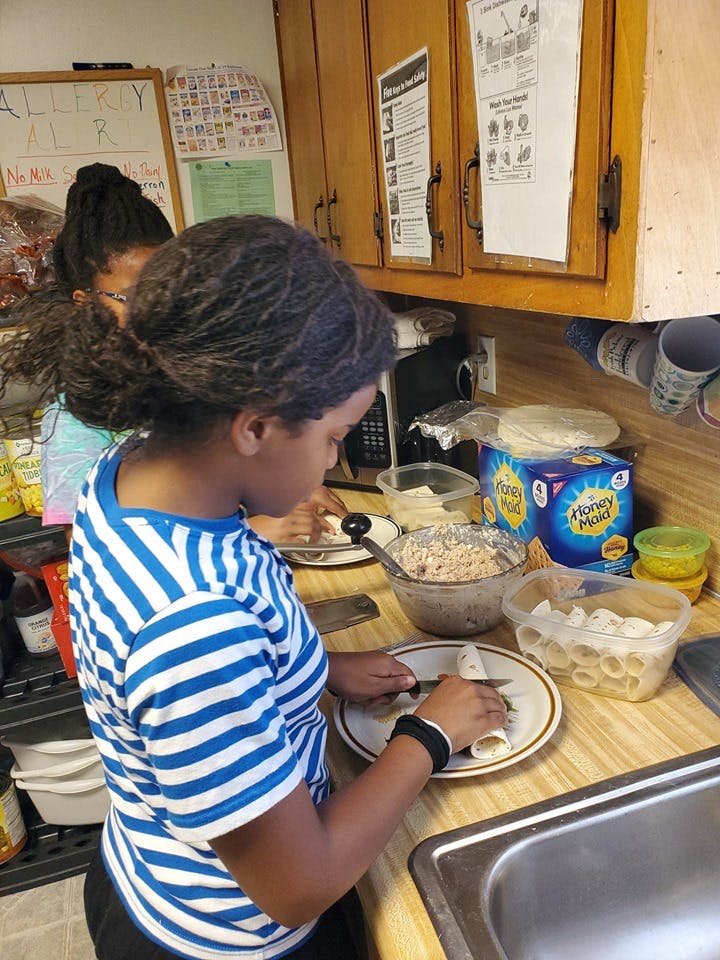 Child in striped shirt preparing food in a kitchen