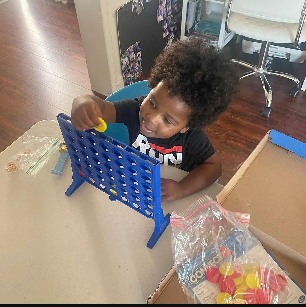 Child playing a Connect 4 board game