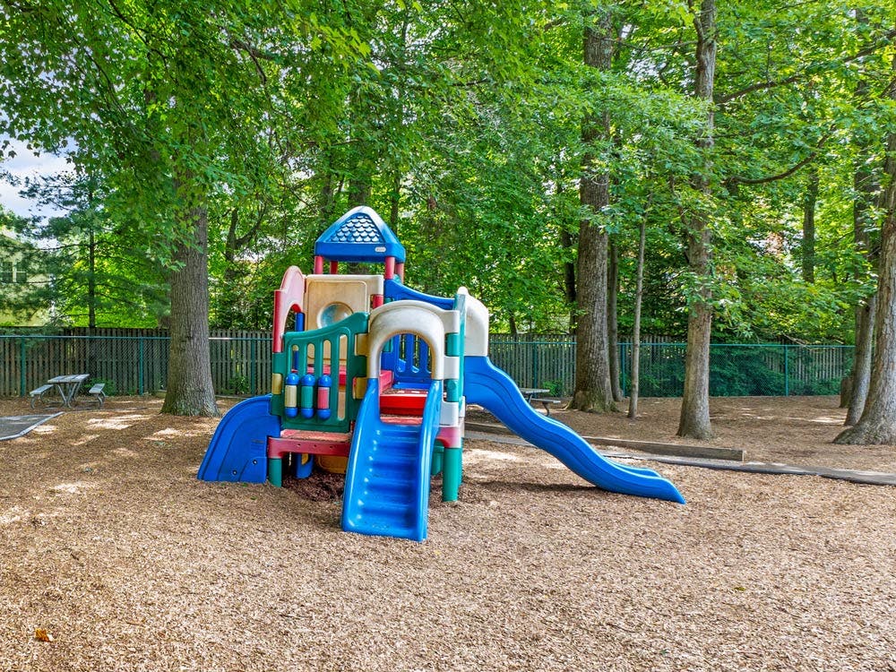 Colorful playground structure with slides on wood chips