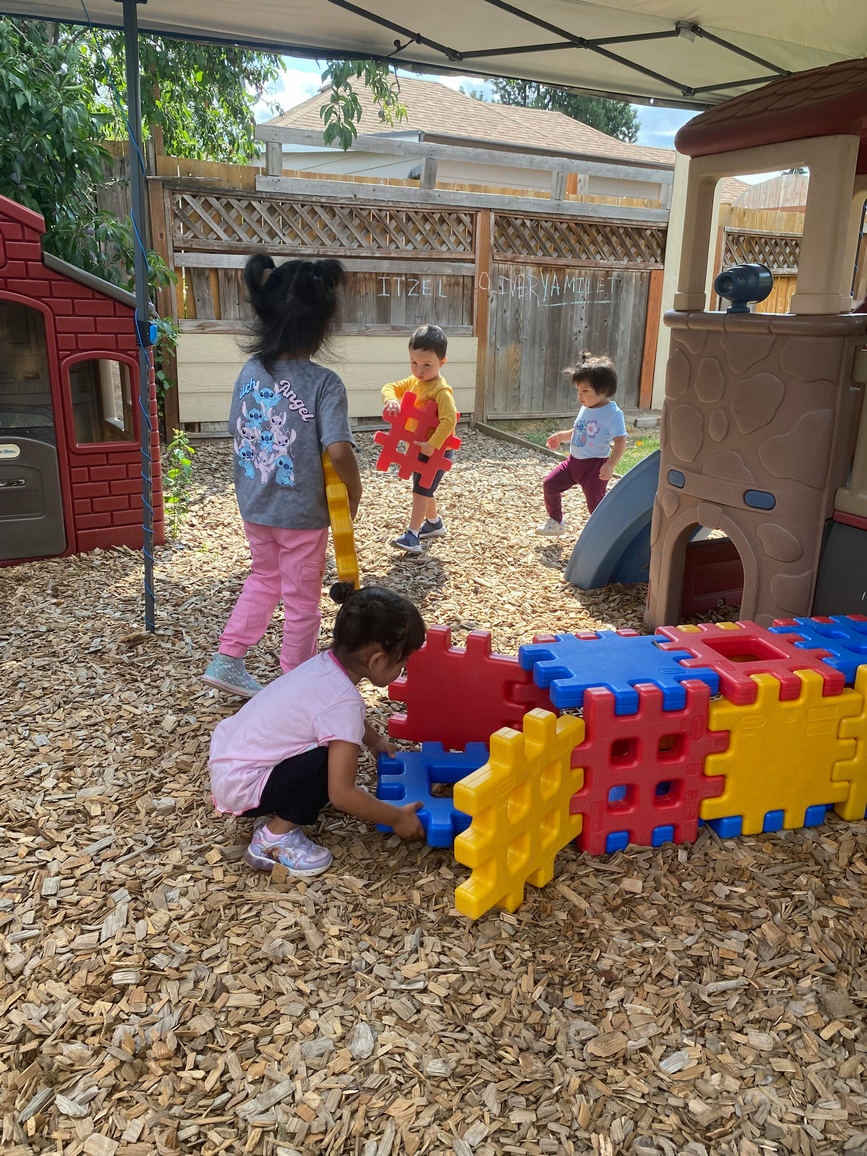 Children playing with large colorful building blocks outdoors