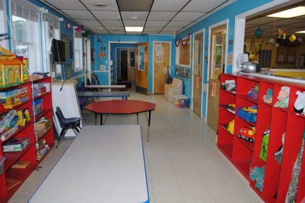 Classroom with red shelves, tables, and blue walls