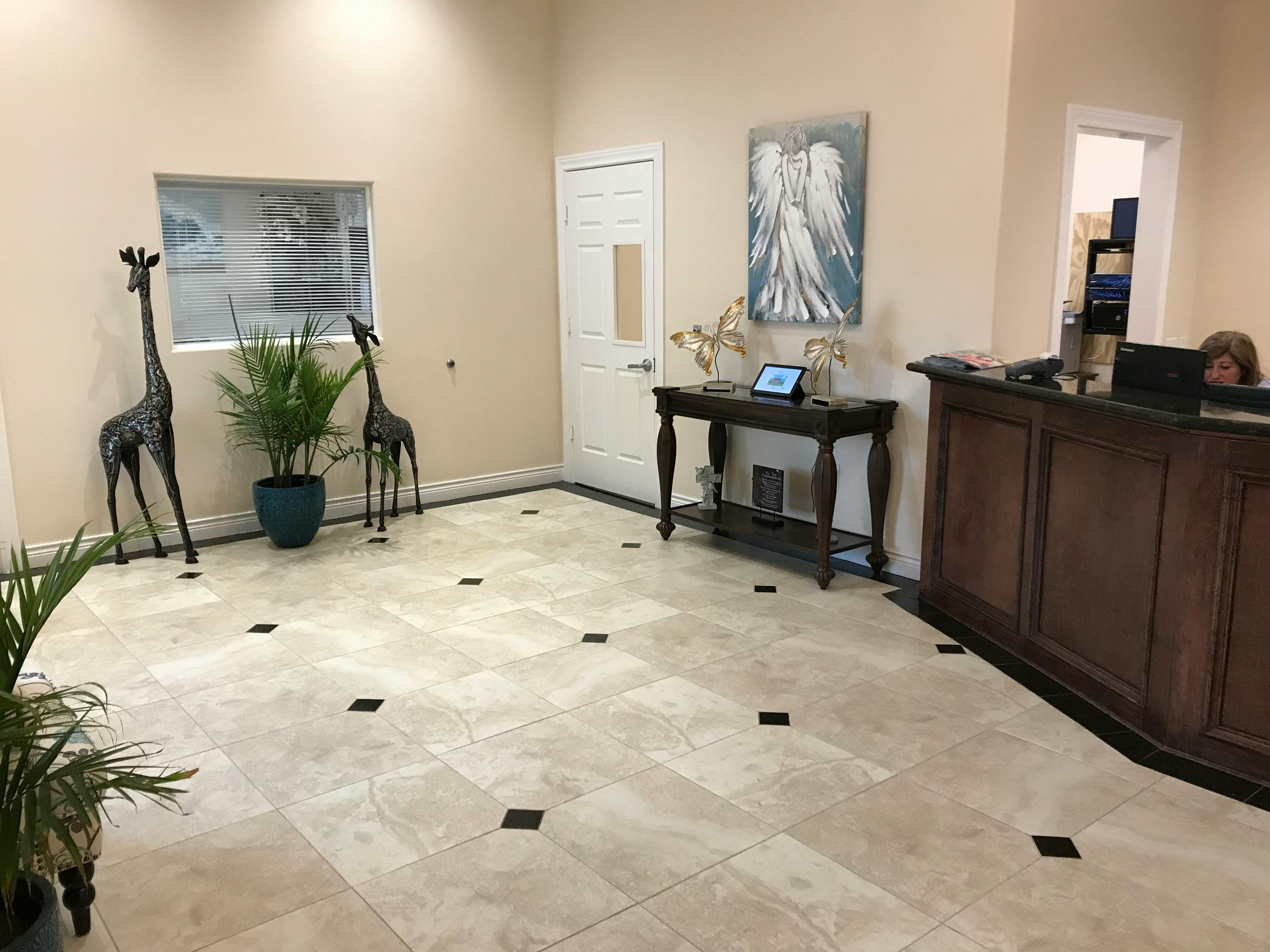 Lobby with a reception desk, decorative giraffes, and a plant