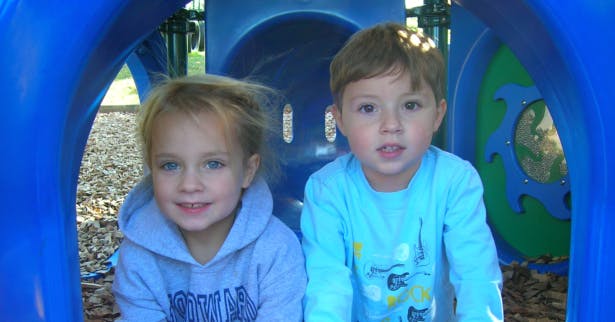 Two children in a blue play tunnel
