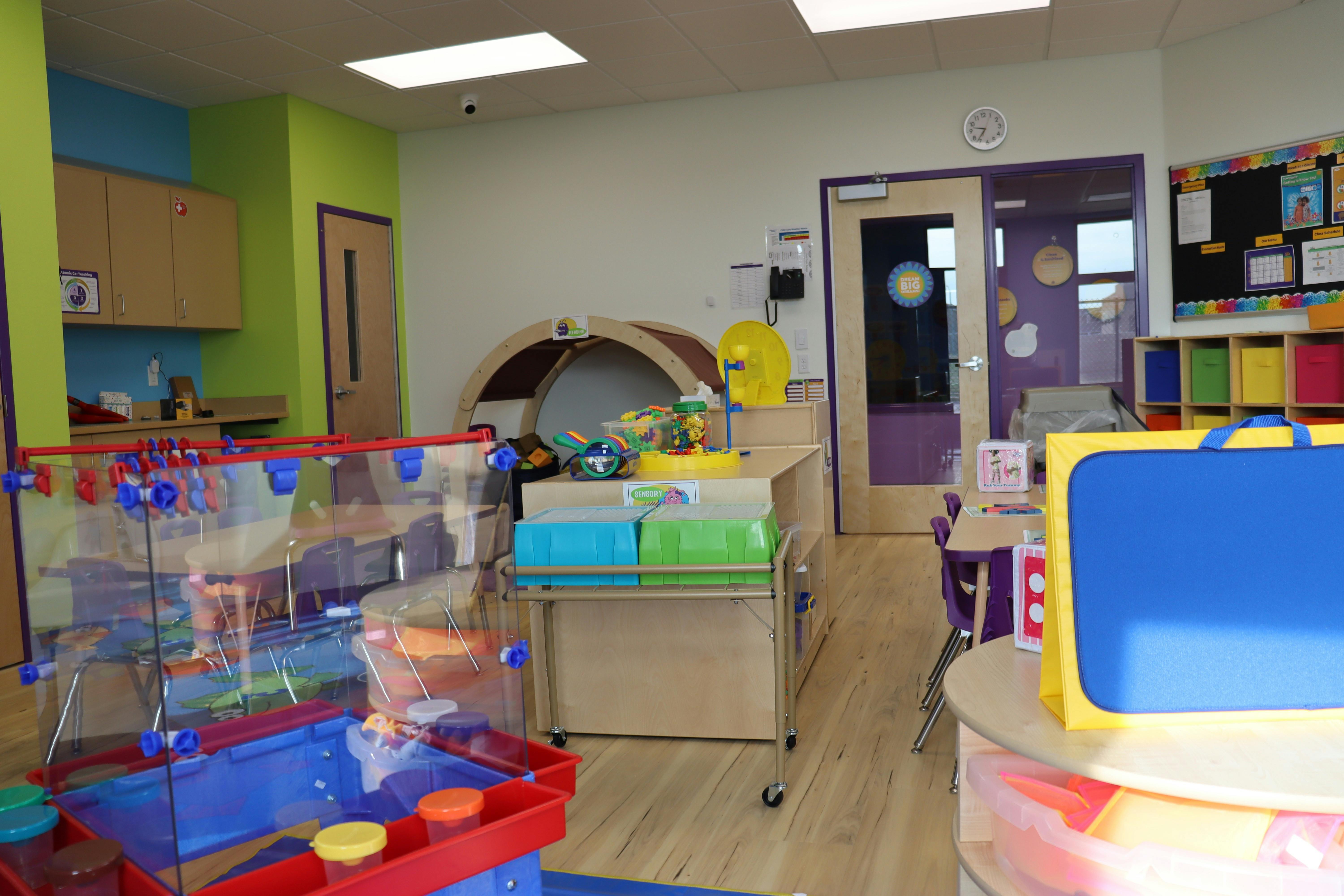 Classroom with activity tables and sensory play area