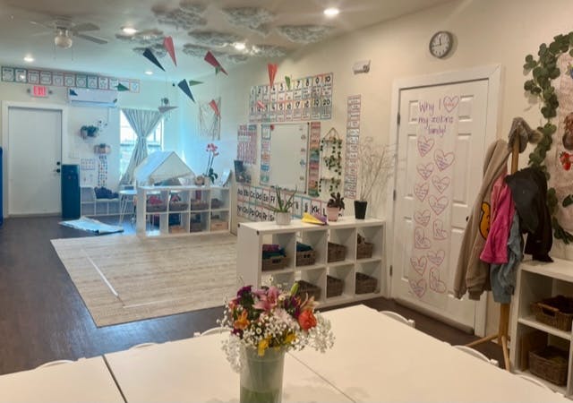 Classroom with tables, shelves, and a play tent