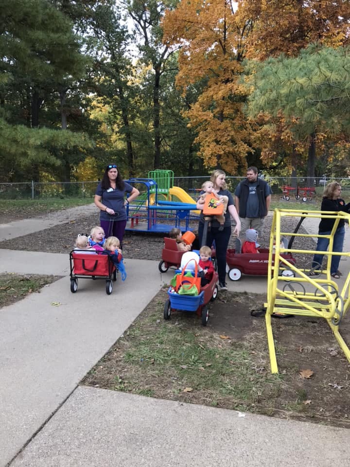 People with children in wagons on a playground