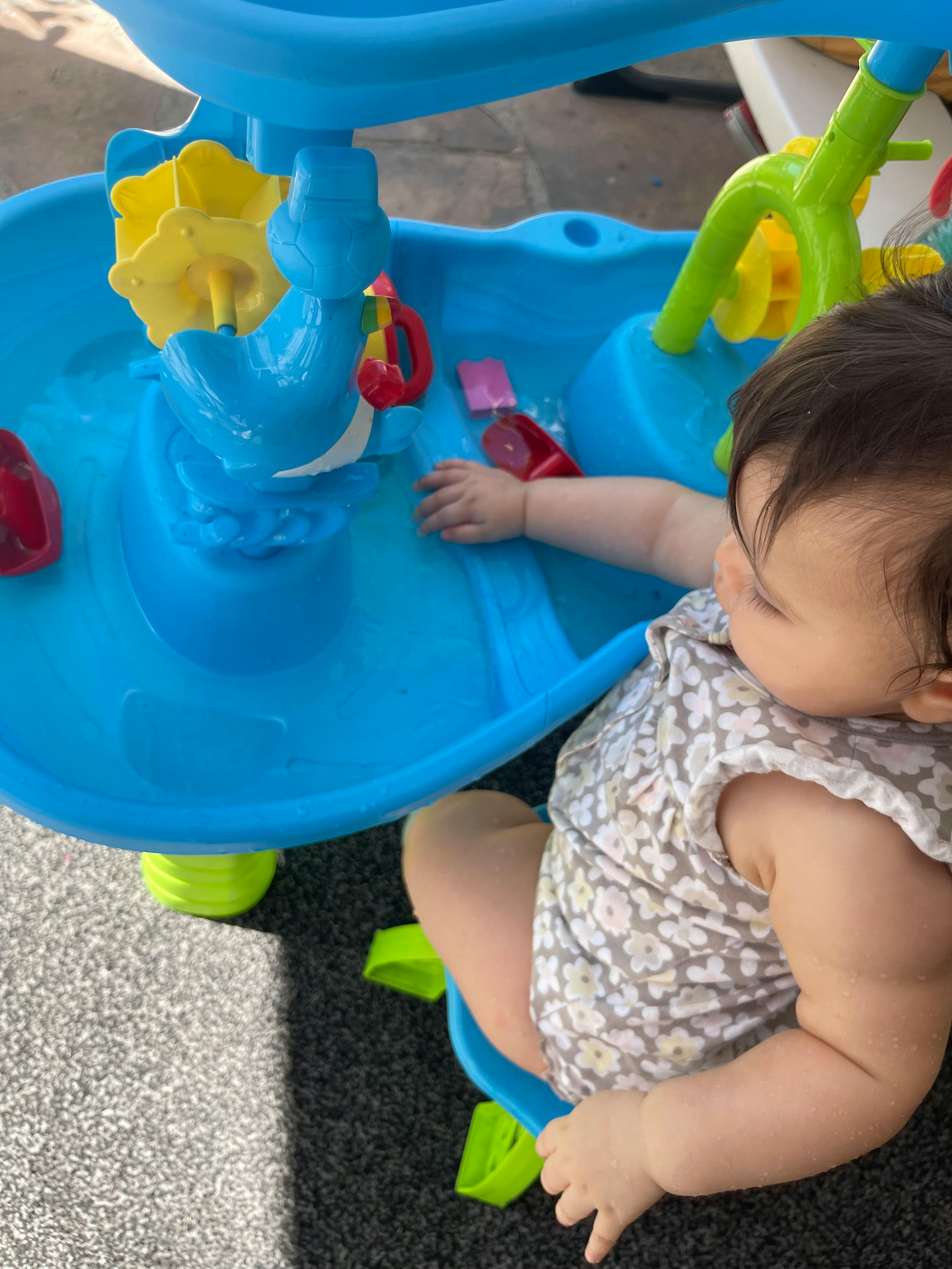 Child playing with a blue water table