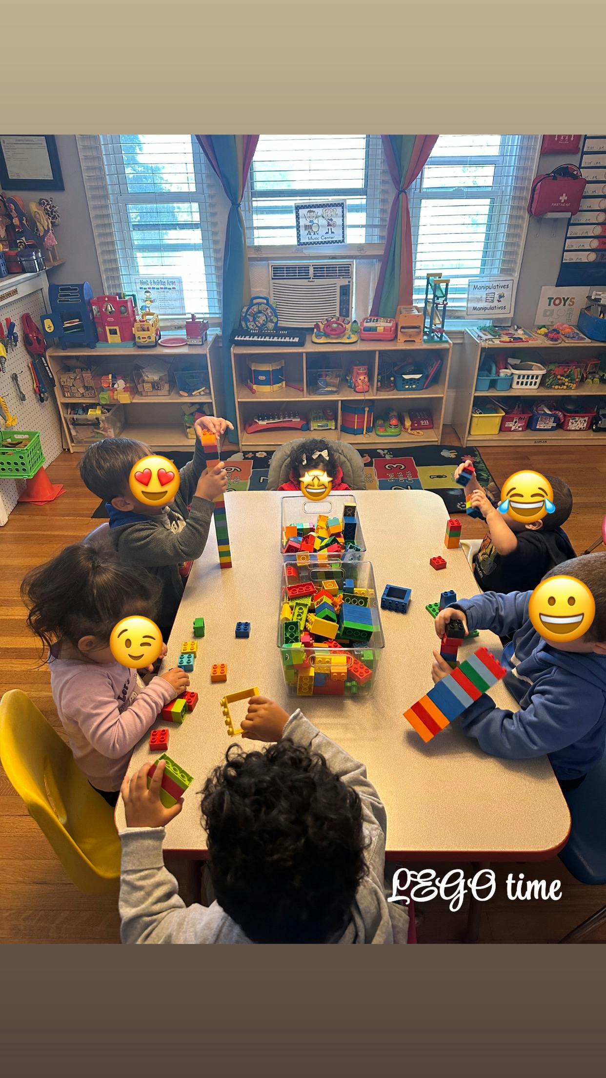 Children playing with colorful building blocks at a table in a classroom