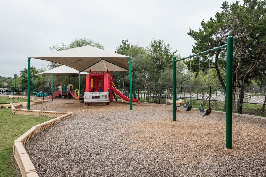 Playground with slides, swings, and shade structure
