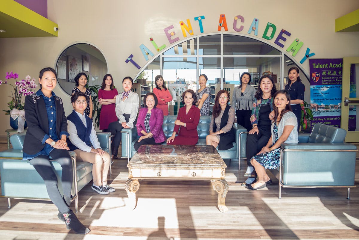 Group of people posing in front of a sign that reads "Talent Academy"