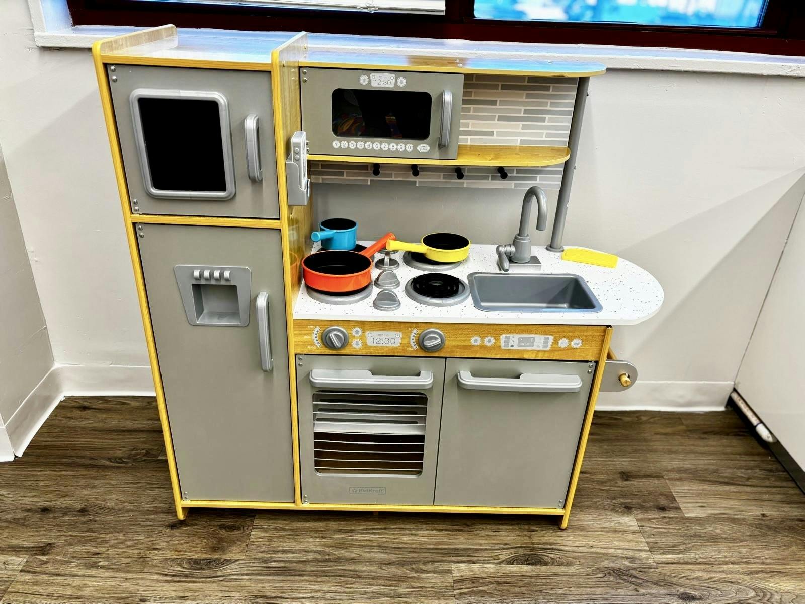 Toy kitchen set with refrigerator, microwave, stove, and sink