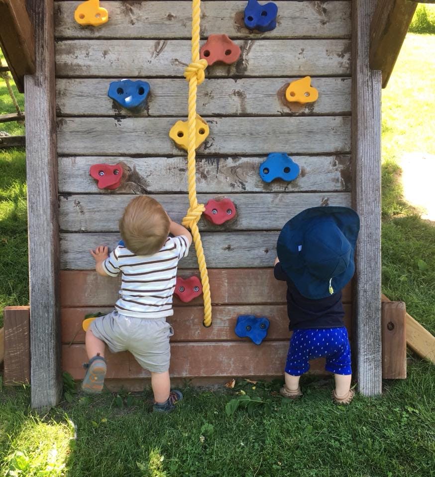 Two children climbing a rock wall