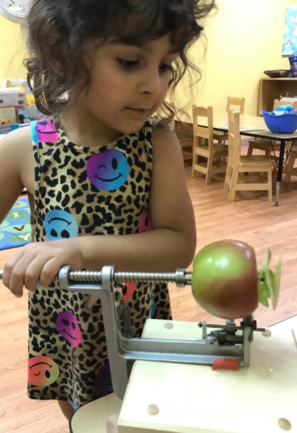 Child using an apple peeler