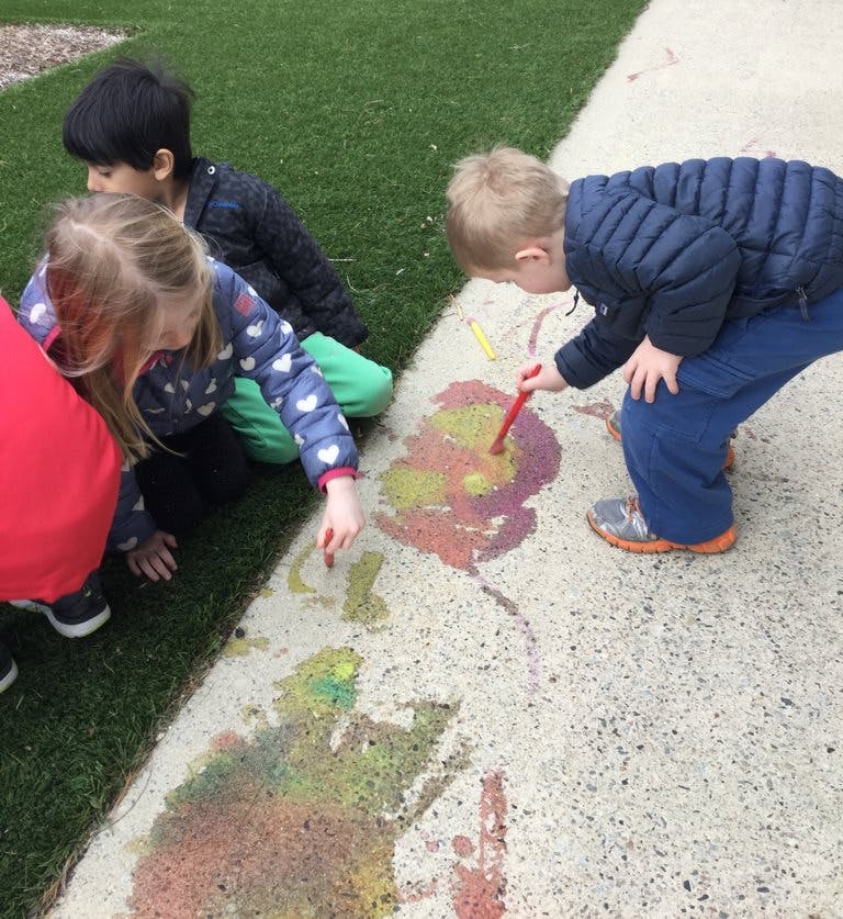 Children drawing on pavement with chalk