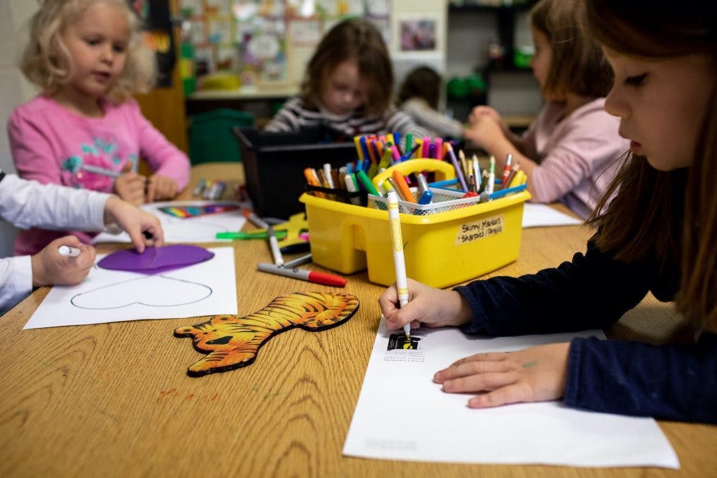 Children drawing at a table in a classroom
