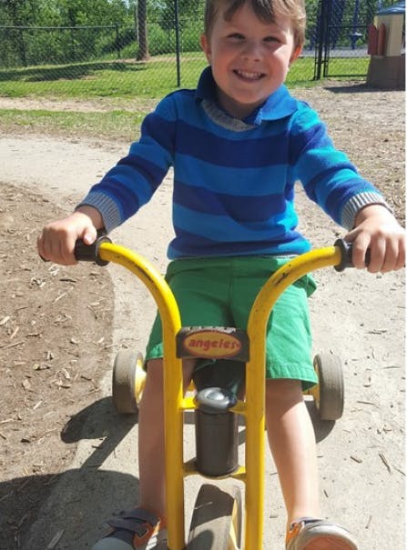 Child on a yellow tricycle