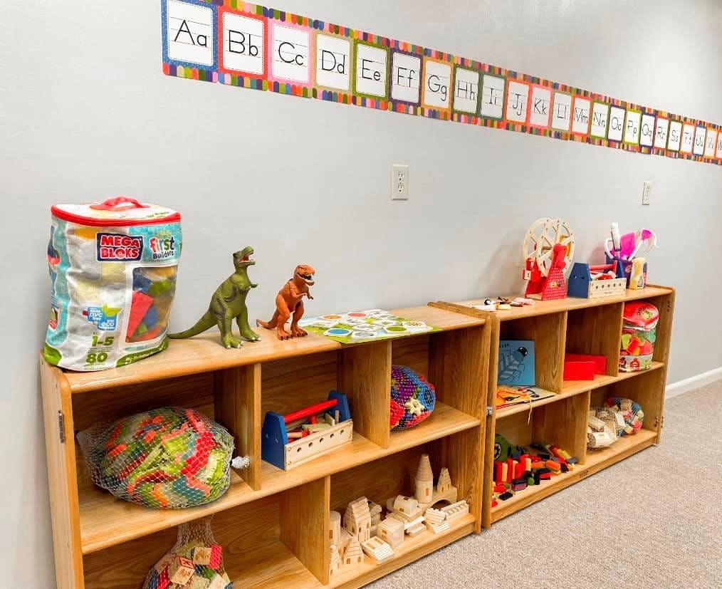 Shelves with toys and an alphabet banner on the wall