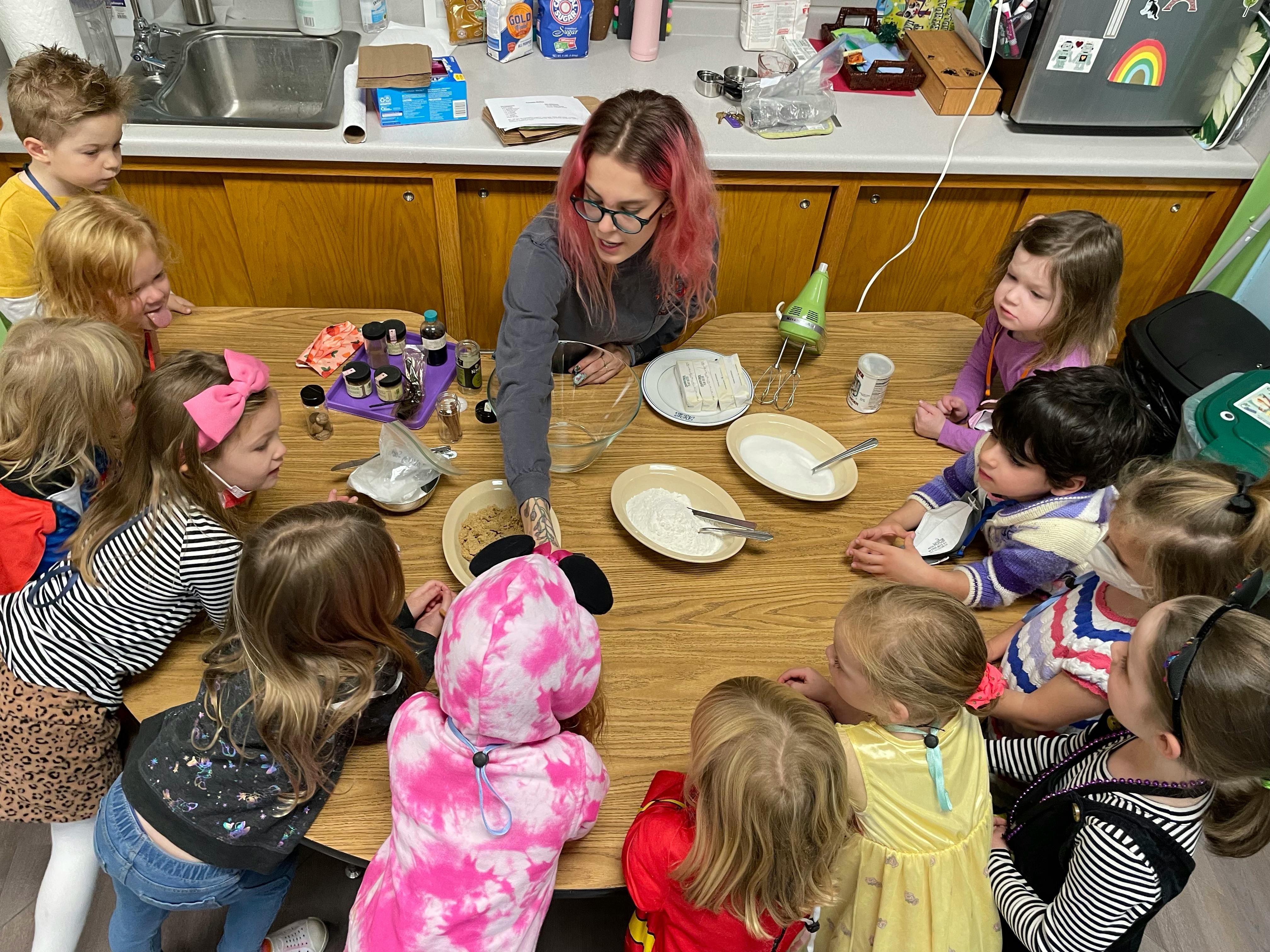 Adult and children gathered around a table with plates and bowls