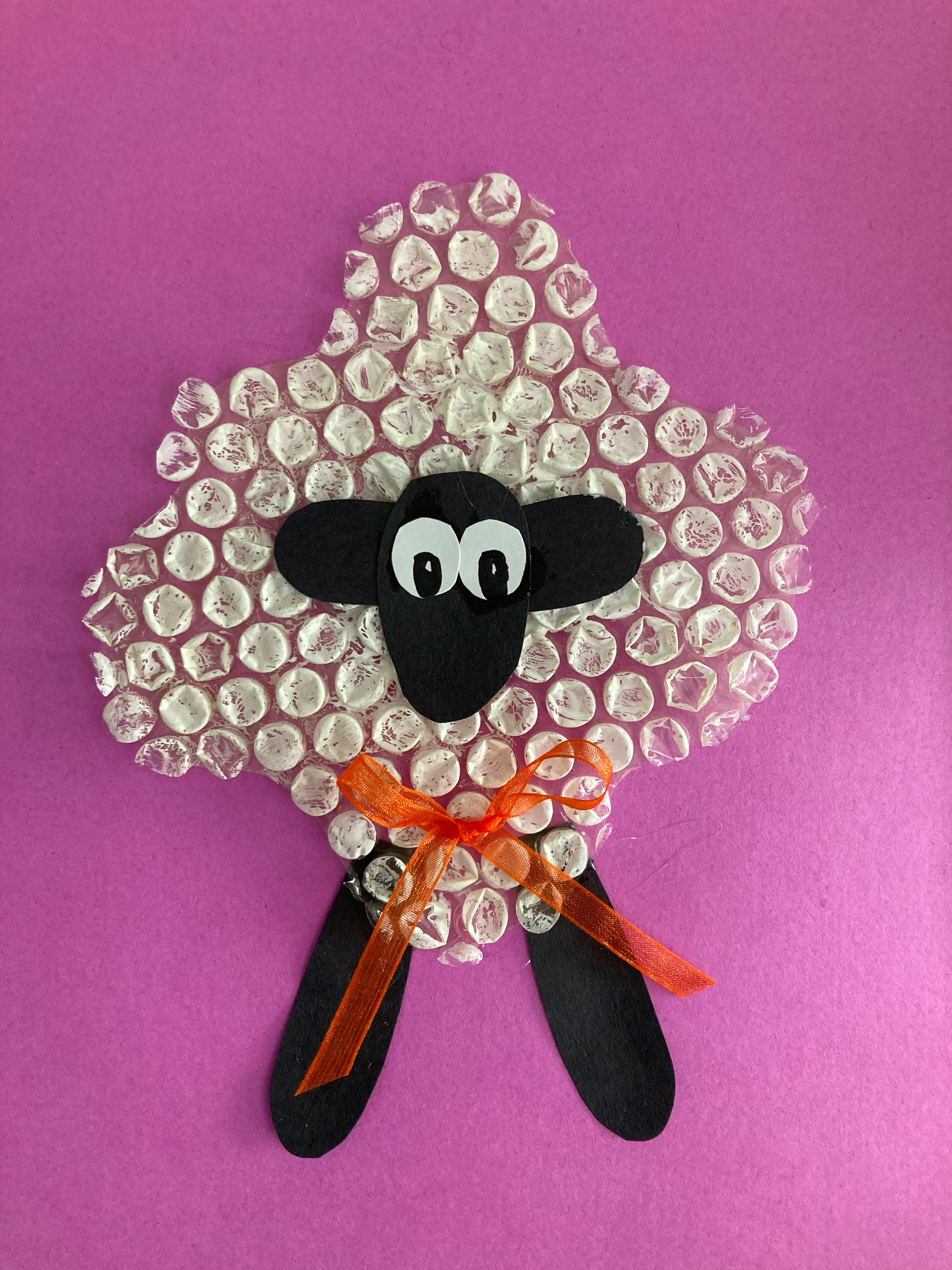 Bubble wrap and construction paper sheep craft with an orange ribbon