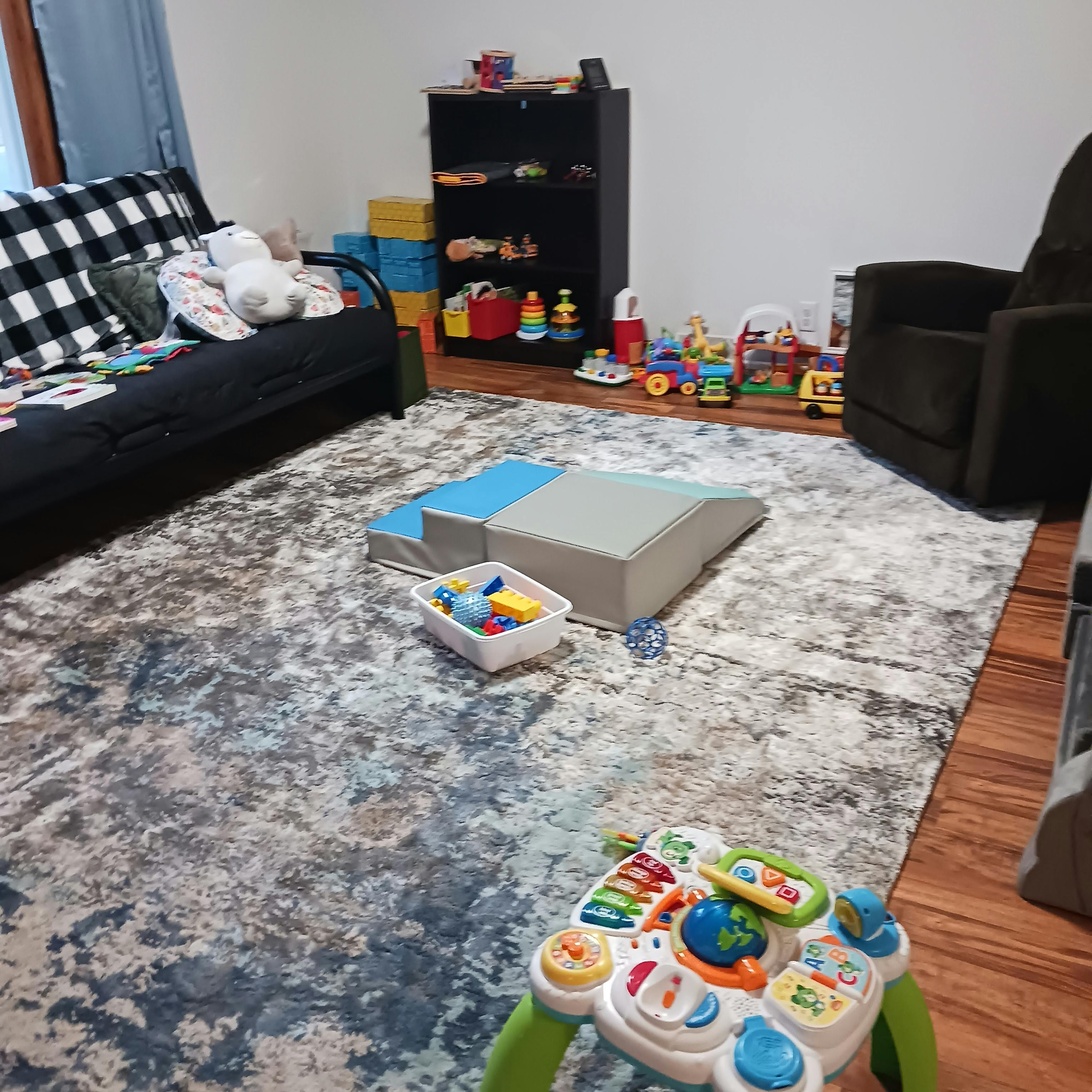 Playroom with soft play equipment, toys, and a sofa