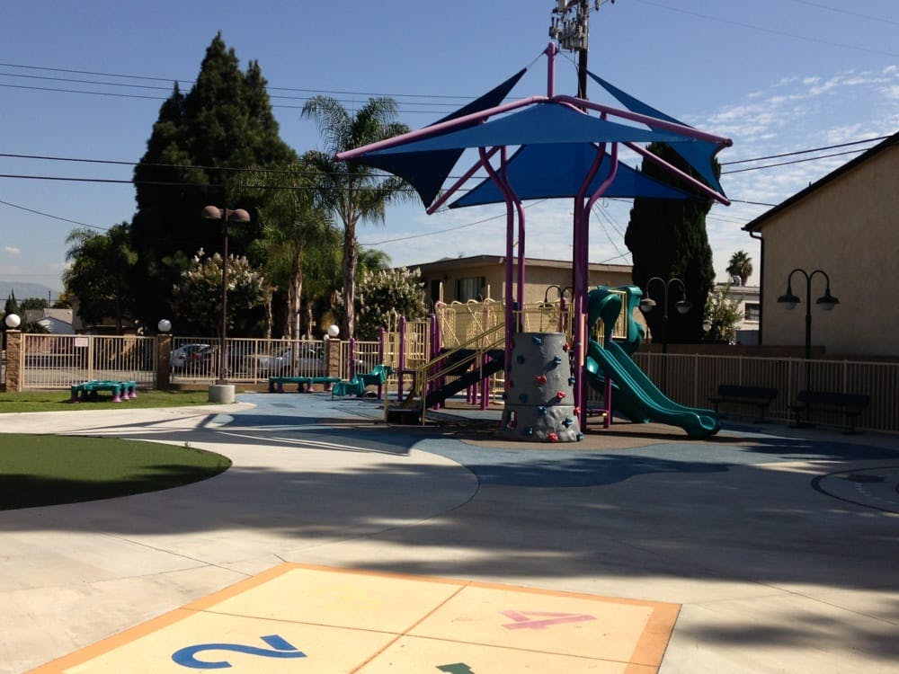 Playground with blue shade structure and green slide
