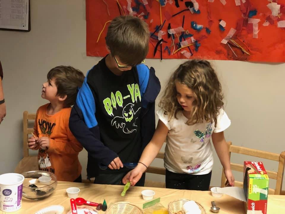 Three children at a table with craft supplies