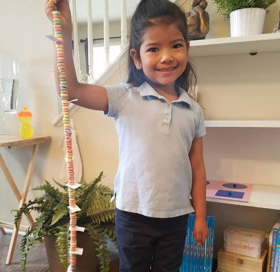 Child holding up a long string of colorful beads