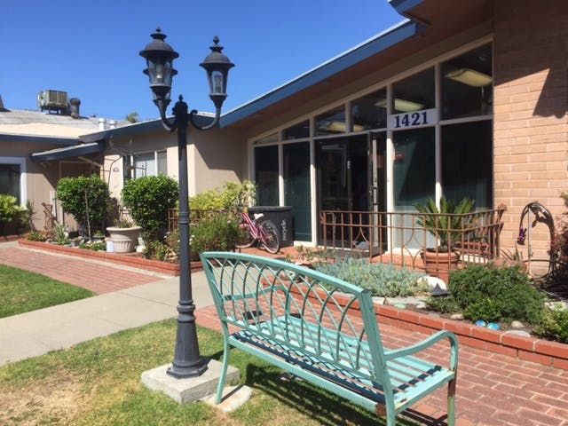 Light post and bench in front of a building with large windows