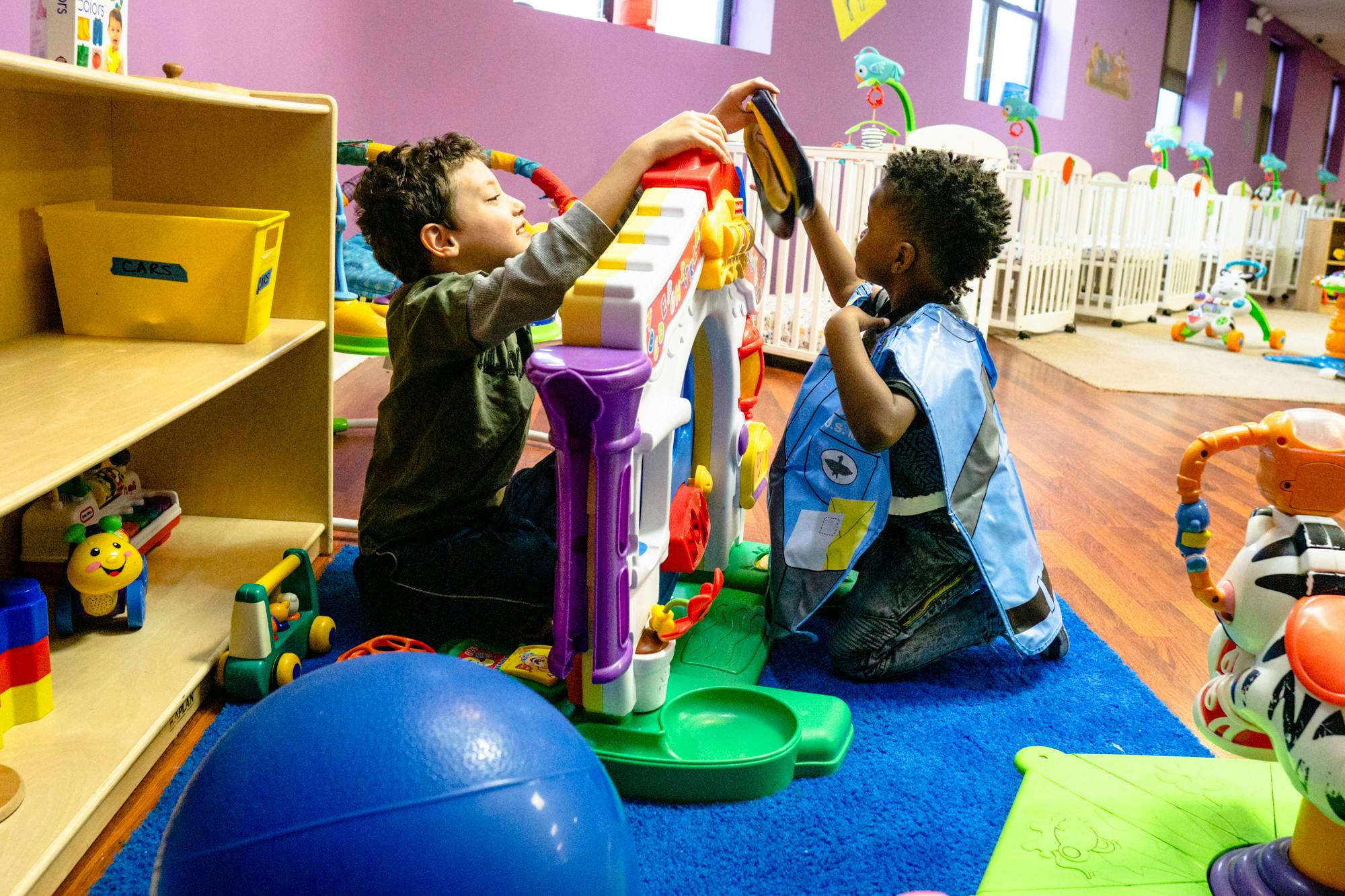 Two children playing with a toy in a classroom