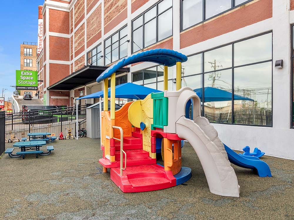 Colorful outdoor playground structure next to a red brick building