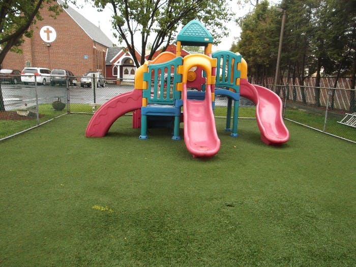 Colorful playground structure with multiple slides on artificial turf