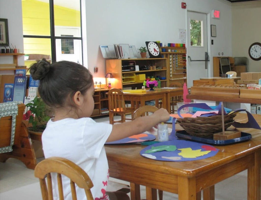 Child at a table doing an activity with craft supplies