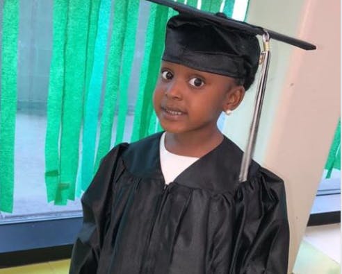 Child in a black graduation cap and gown
