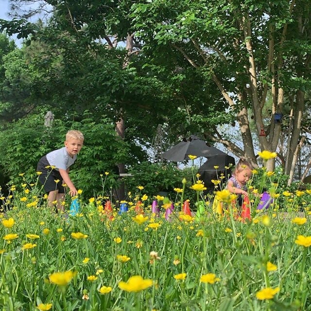 Two children playing in a field of yellow flowers