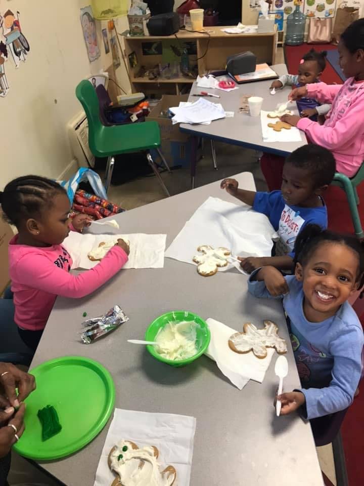 Children decorating cookies at a table