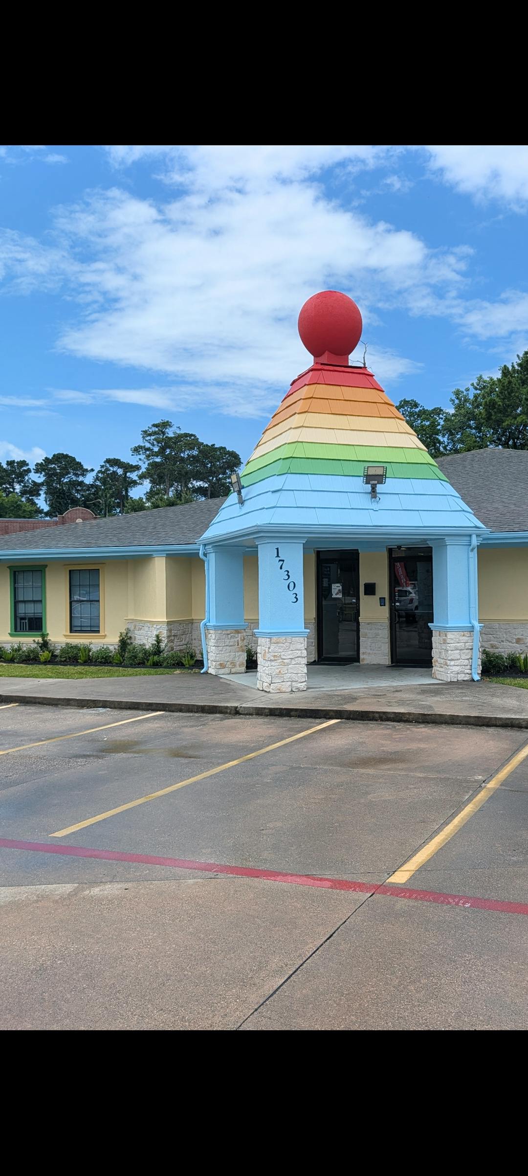 Building exterior with a rainbow roof and the address 17303
