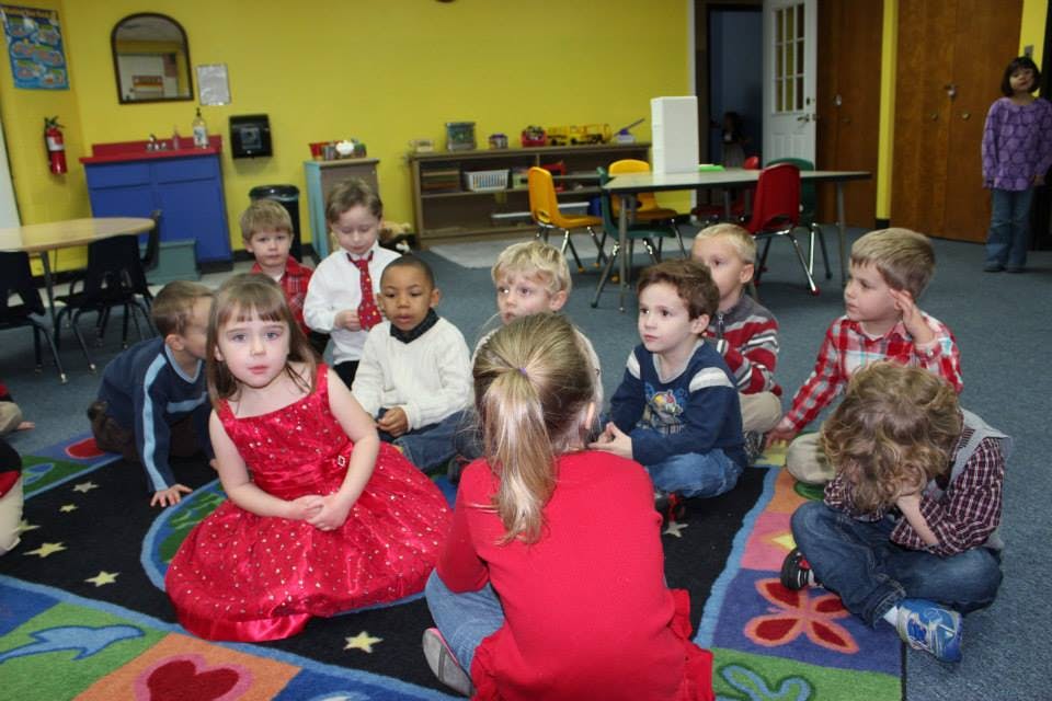 Group of children sitting on a rug in a classroom