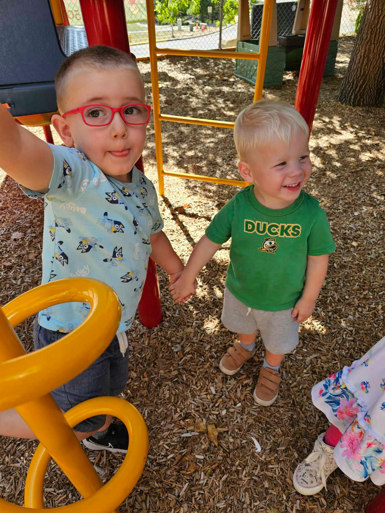 Two children holding hands on a playground