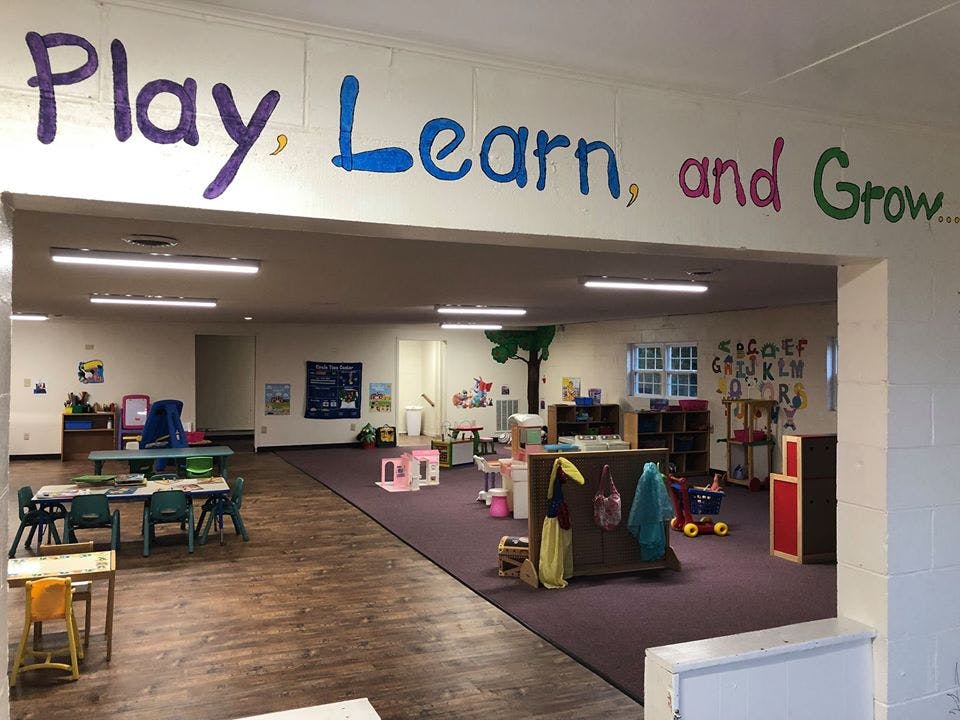 Classroom with text "Play, Learn, and Grow" above an archway