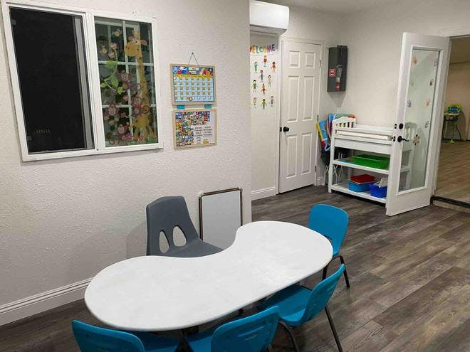Classroom with a white kidney-shaped table and blue chairs
