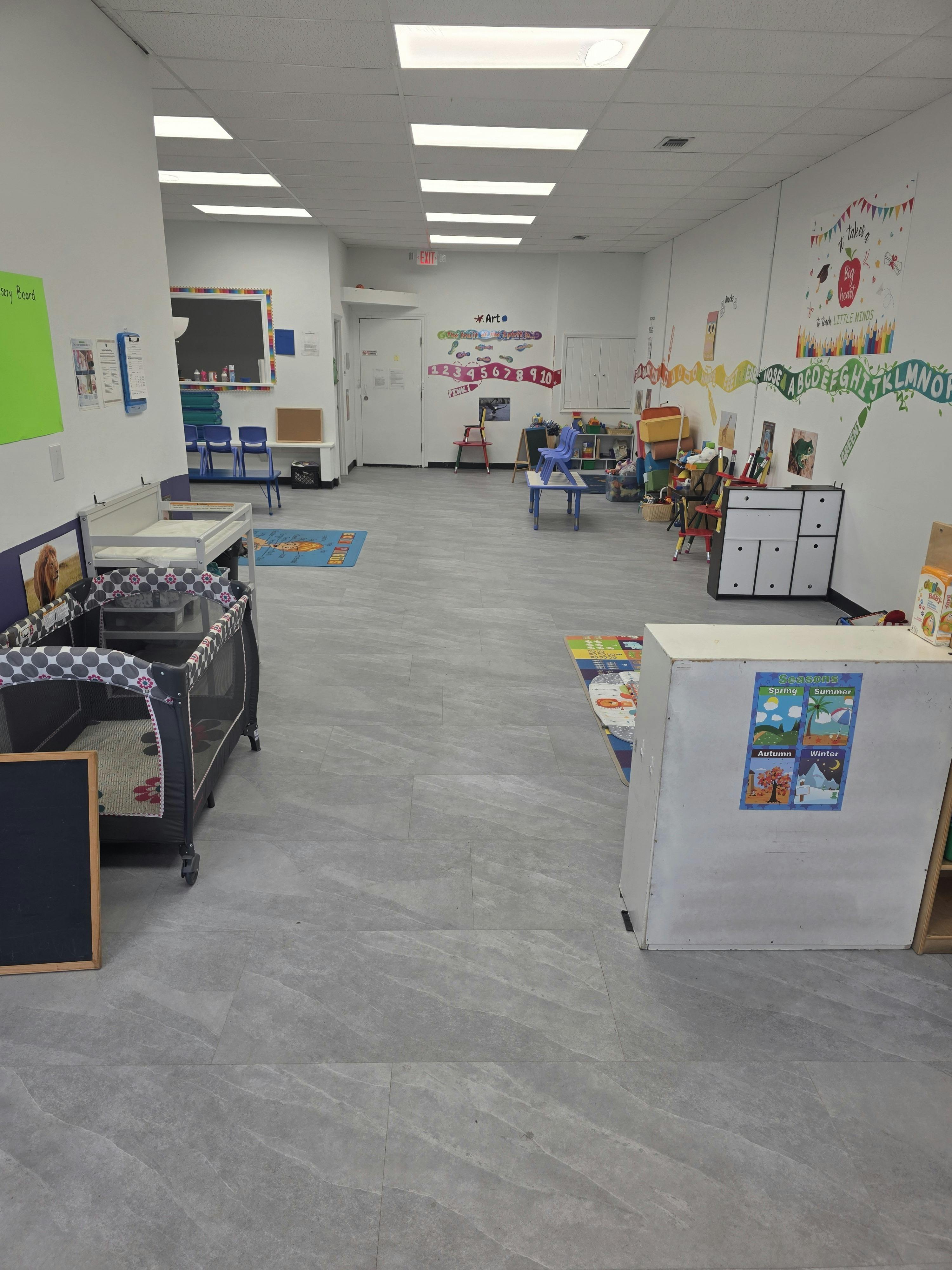 Empty child care classroom with play equipment and educational wall decor