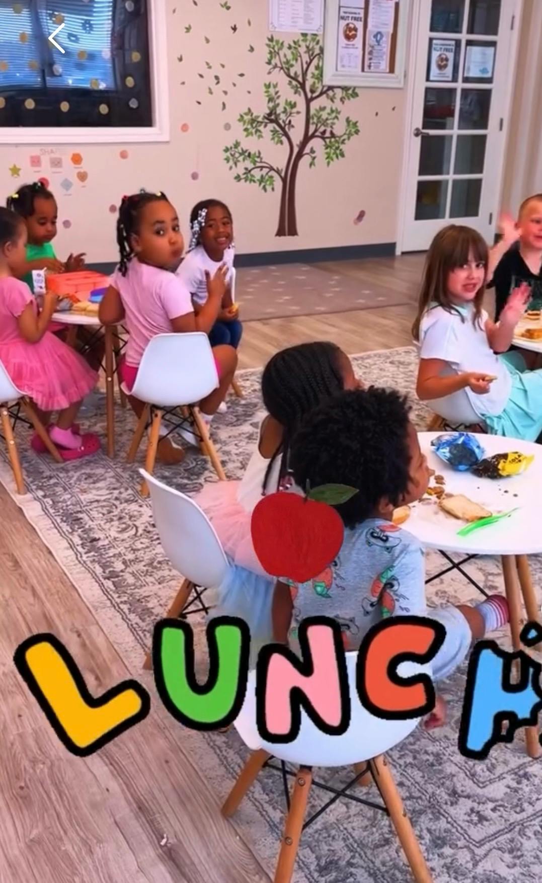 Group of children eating lunch at tables in a classroom