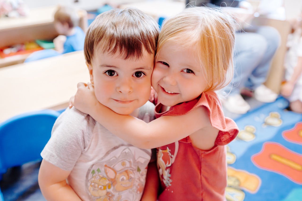 Two children hugging in a classroom