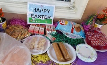 Table with food items and a "Happy Easter" sign