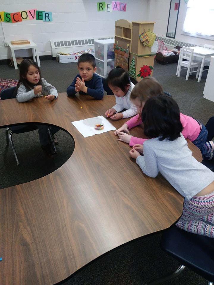 Children gathered around a table in a classroom