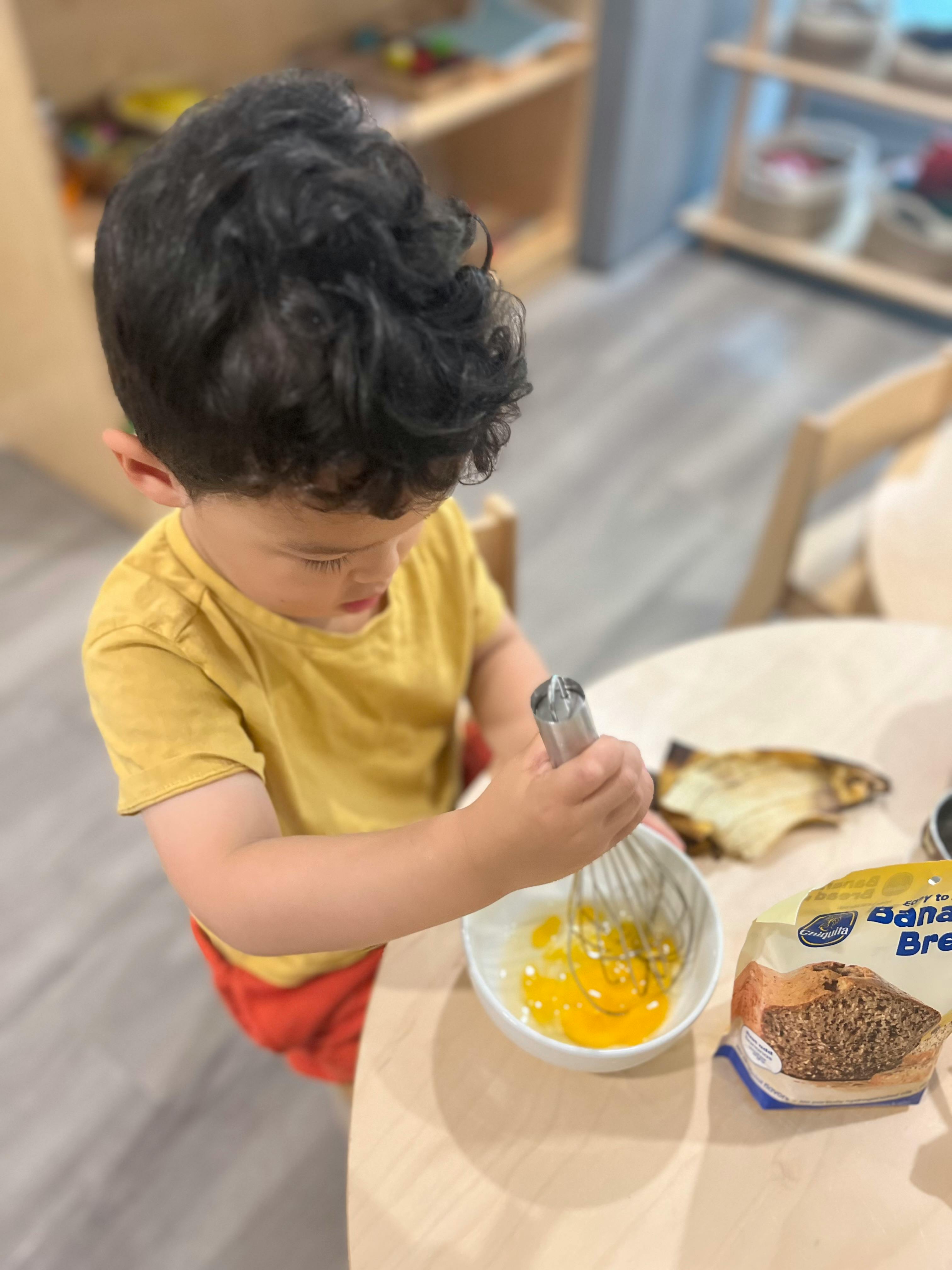 Child whisking eggs in a bowl