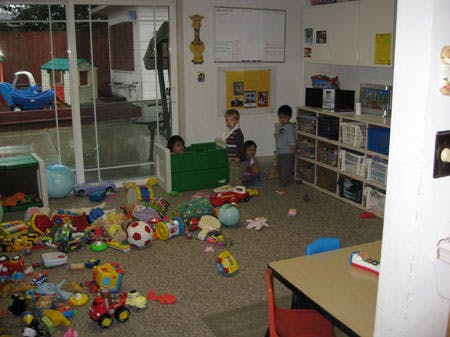 Children playing in a room with toys scattered on the floor