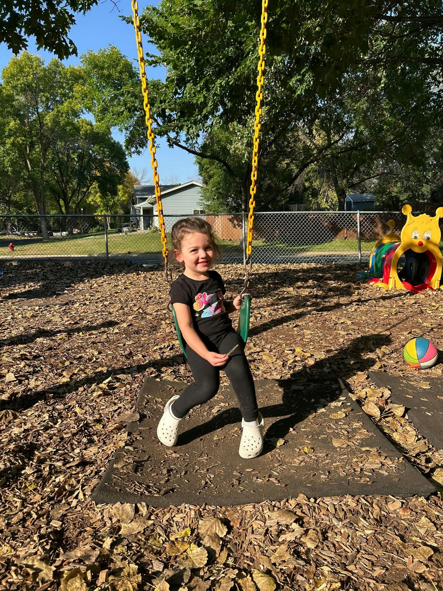 Child sitting on a swing at a playground