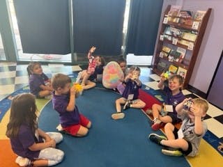 Children sitting on a rug in a room